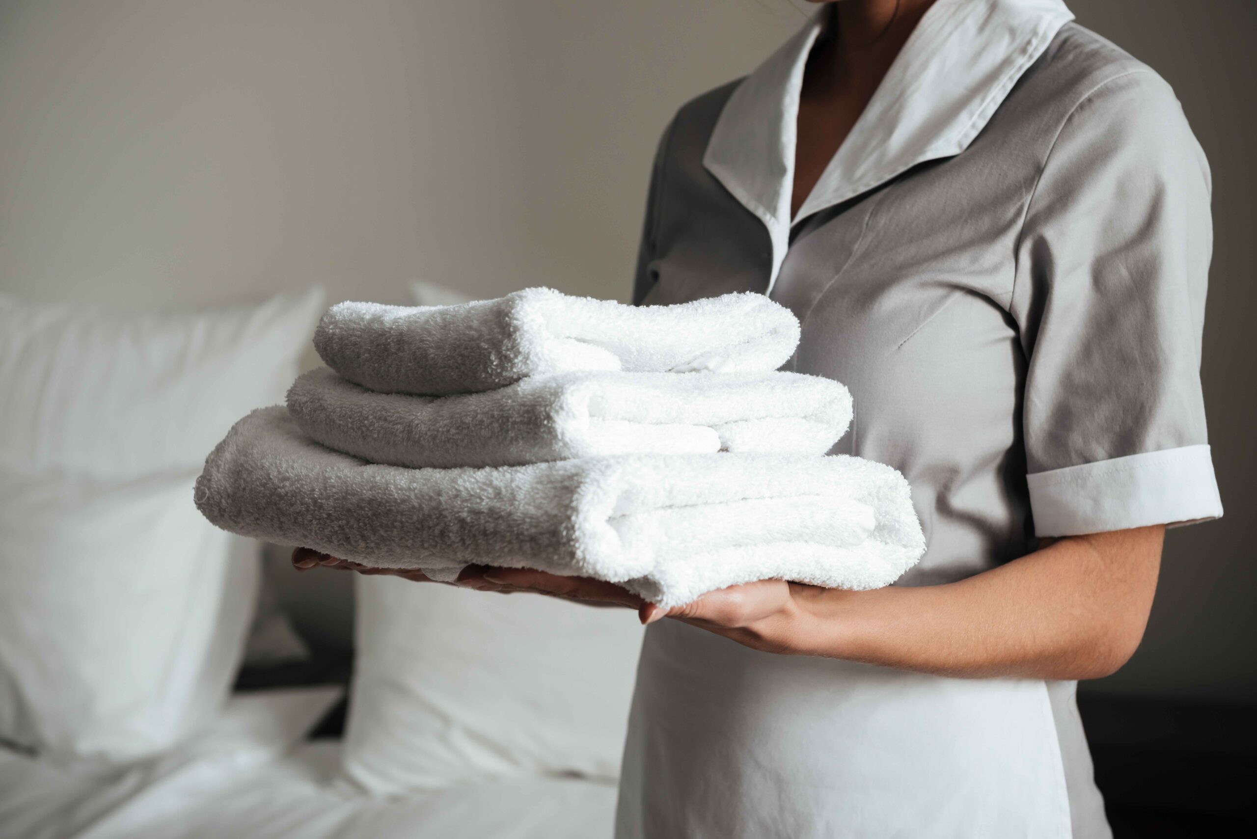 Young maid holding folded towels